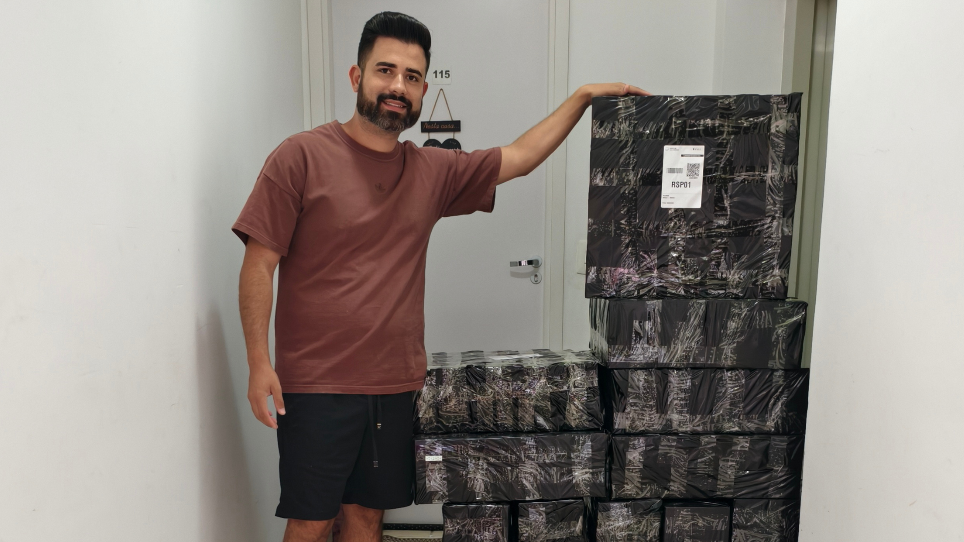 Luan ao lado de uma pilha de pedidos embalados