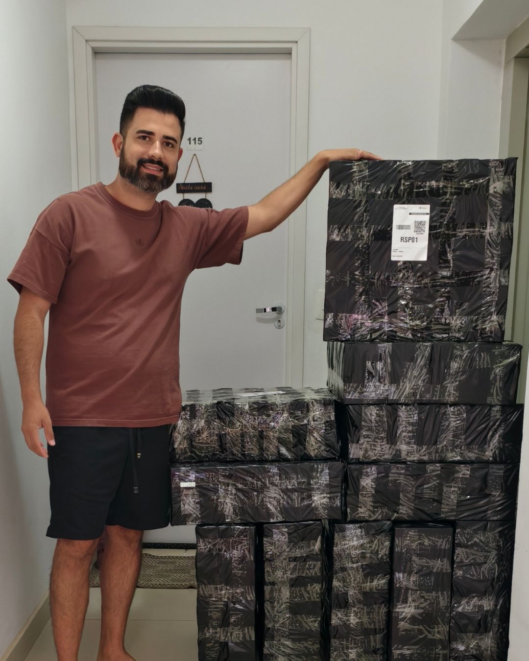 Luan ao lado de uma parede de caixas prontas para envio
